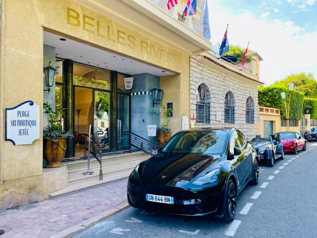 Tesla Model Y avec chauffeur privé devant l’Hôtel Belles Rives à Antibes – Trip Riviera