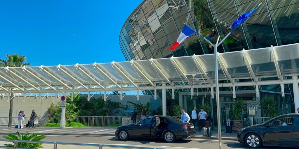 Deux berlines noires avec chauffeurs privés devant l’aéroport Nice Côte d’Azur – service VTC haut de gamme Trip Riviera